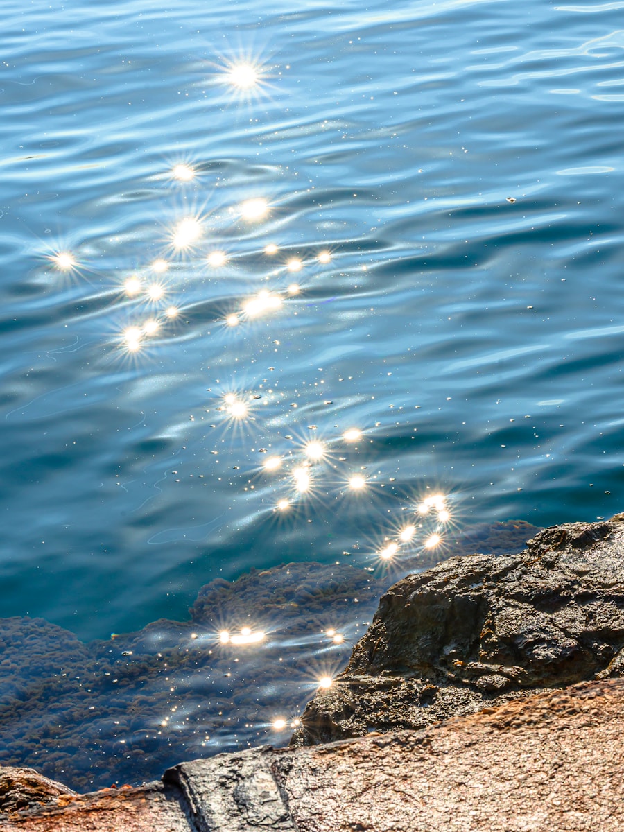 Sparkling sunlight on blue ocean water near rocks